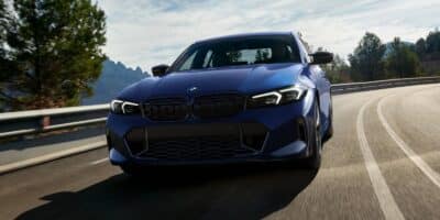 Blue BMW m340i driving down the highway.