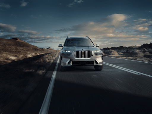 A gray BMW x7 driving down a highway.