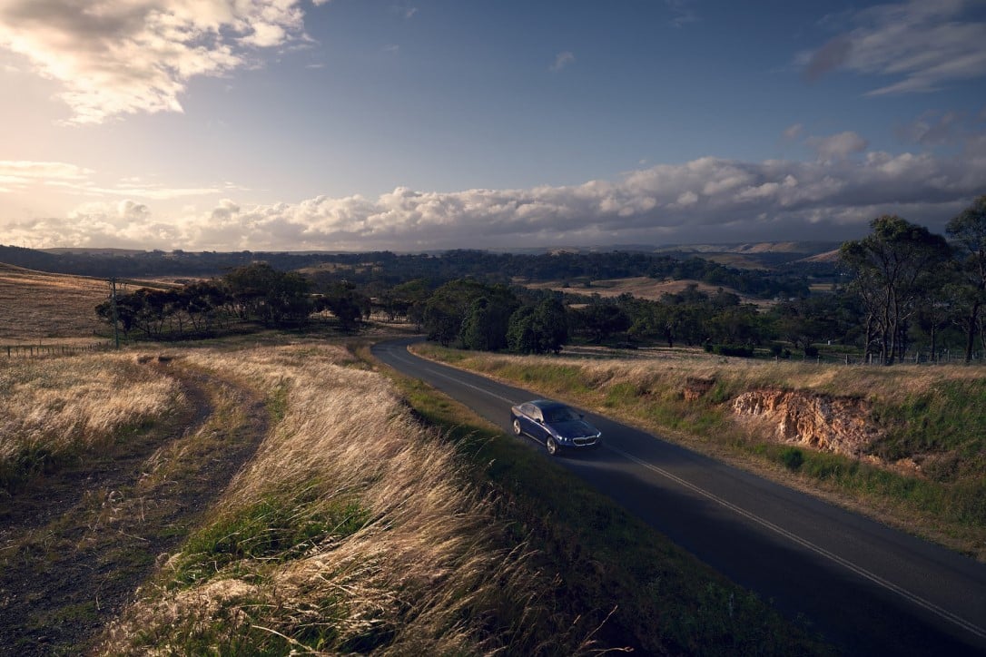 A BMW 5 series driving down a scenic highway.