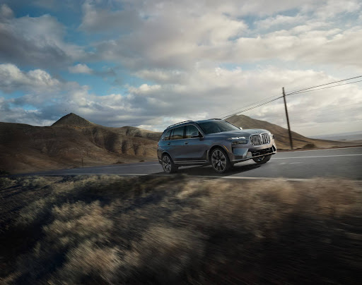 A BMW SUV driving on the highway  with rear cross traffic alert