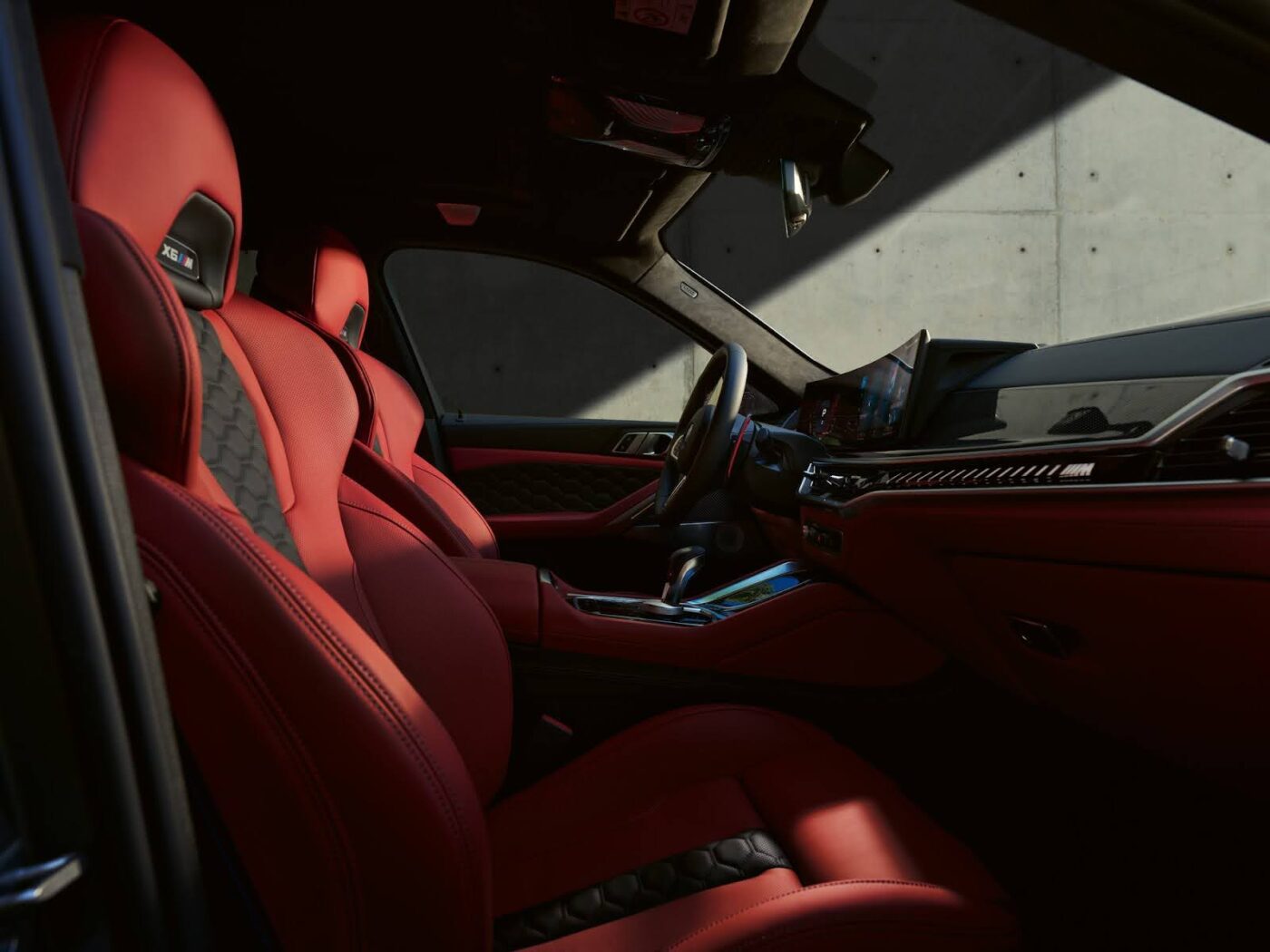 Luxurious interior of the BMW X6 featuring premium red leather seats and high-tech dashboard controls.