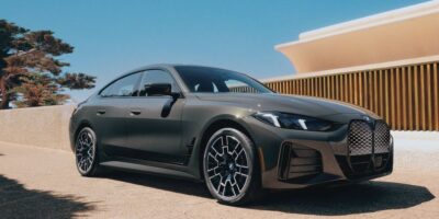 Front view of the 2025 BMW i4 in matte gray, showcasing its sleek aerodynamic design and signature kidney grille.