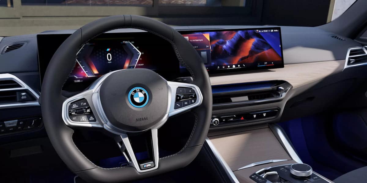 nterior view of the 2025 BMW i4 dashboard, featuring a curved 14.9-inch infotainment display and advanced controls