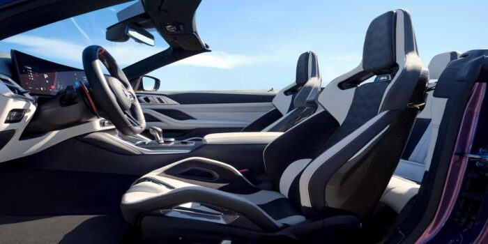 Interior of the 2025 BMW M4 Convertible featuring premium leather bucket seats with carbon fiber accents, ergonomic design, and an open-air driving view.