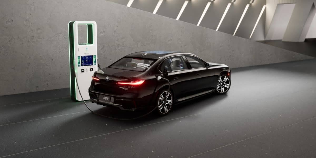 Rear view of a black 2026 BMW i7 charging at a modern electric vehicle charging station in a sleek indoor setting